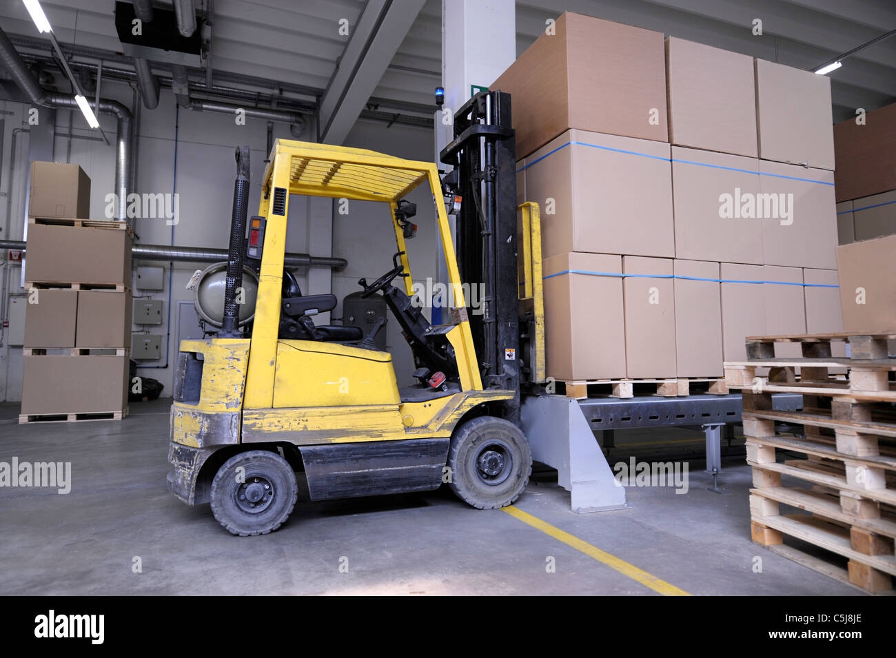 forklift with carton boxes in factory Stock Photo