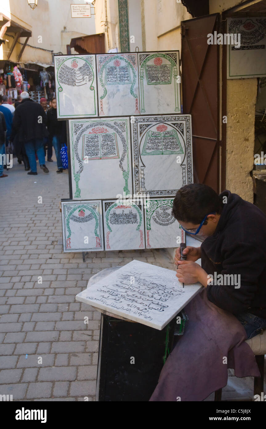 Artisan carving Arabian letters Medina (Fes el-Bali) old town Fez northern Morocco Africa Stock Photo