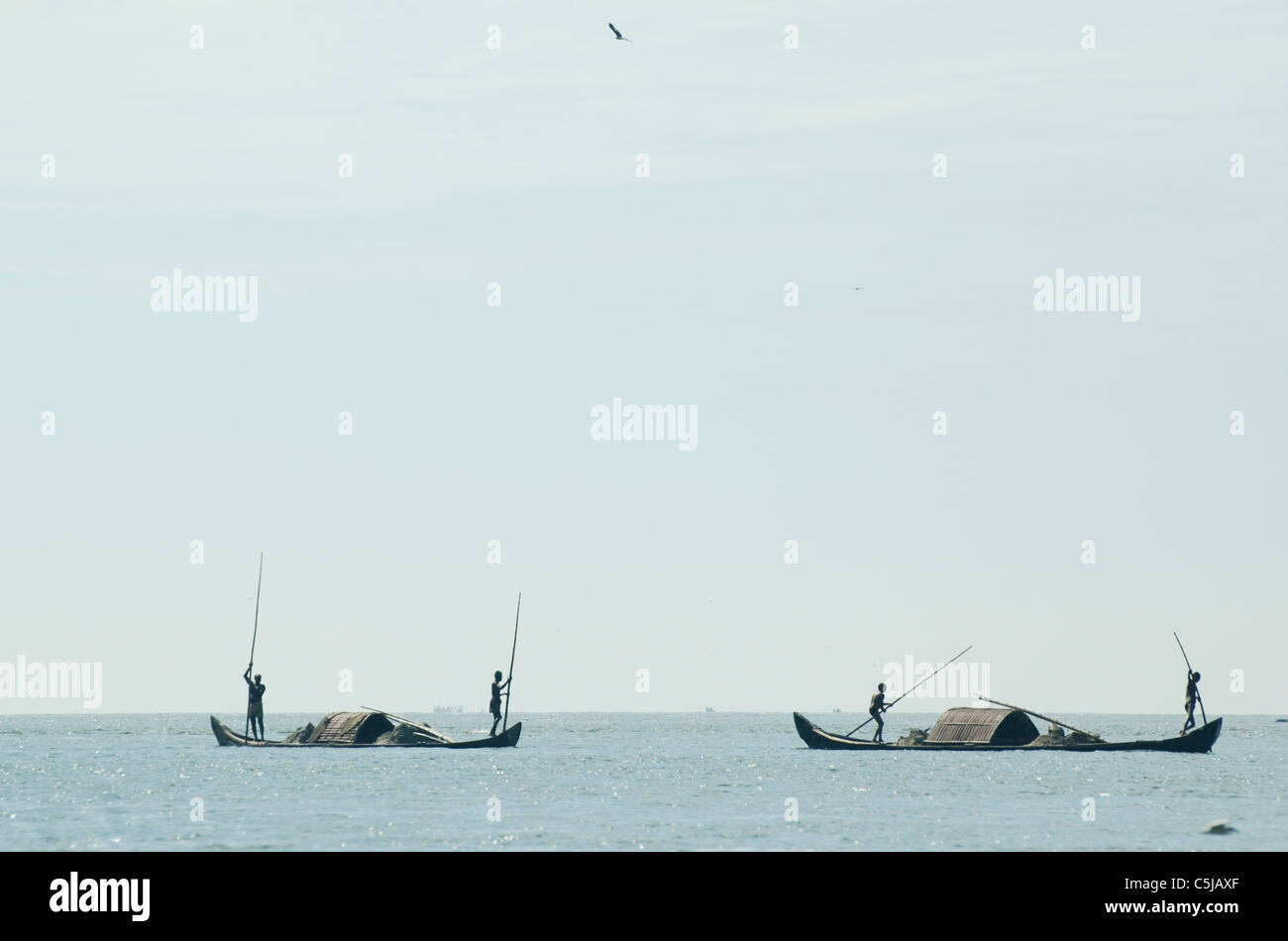 India, Kerala, Backwaters. Working indian men on their boat (punt) in the backwaters between Kollam to Allepey. Stock Photo