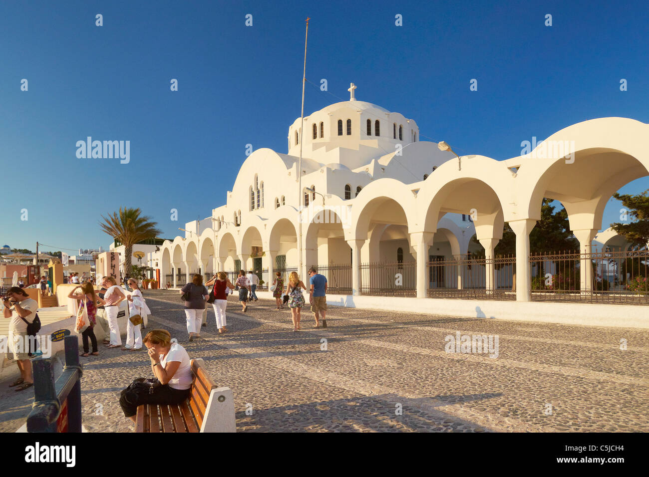 Sidewalk with tourists and Orthodox Cathedral in Thira (Fira), Santorini Island, Cyclades Islands, Greece Stock Photo