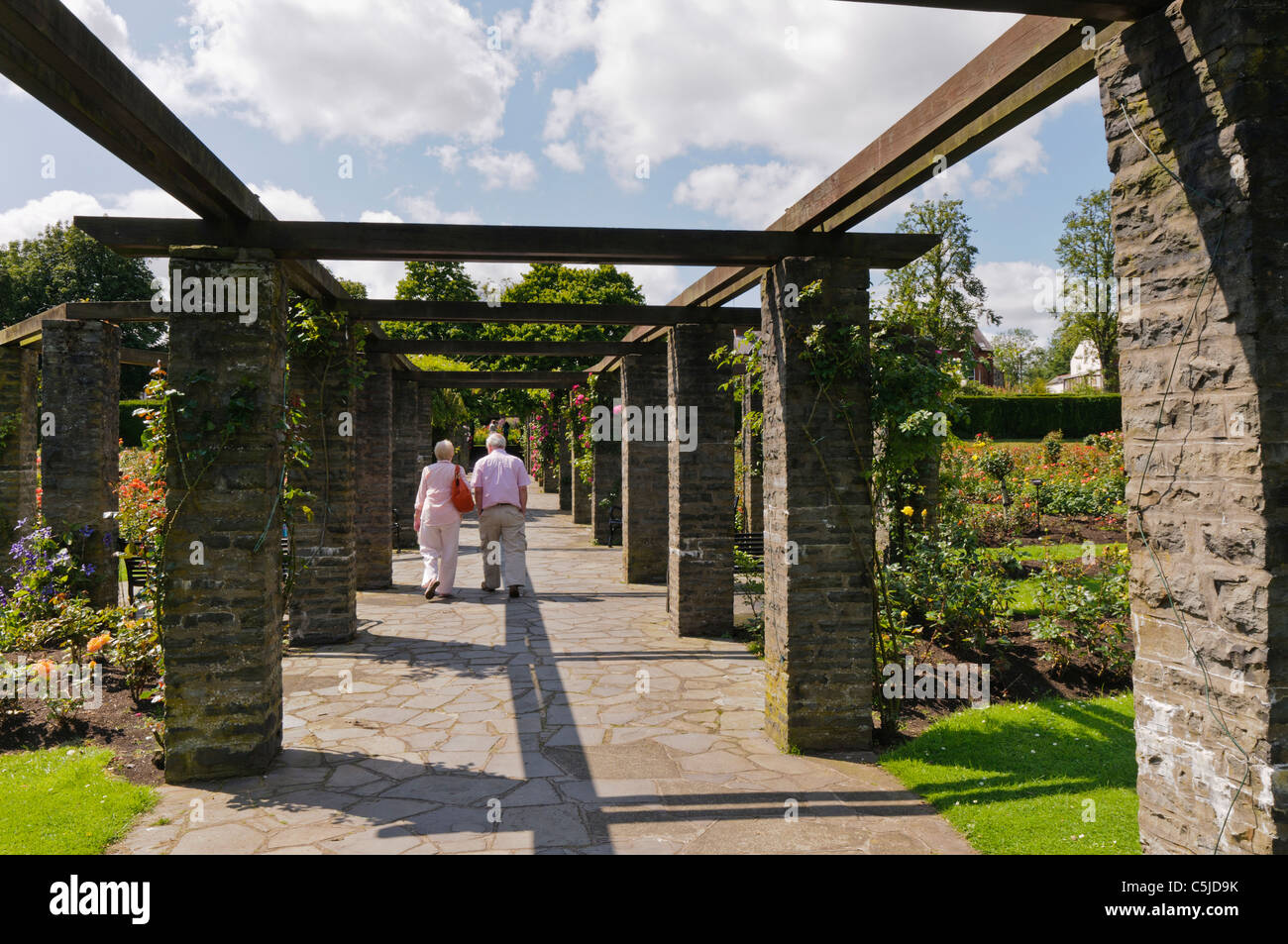 Elderly couple walk through a pergola in Belfast's Botanic Gardens Stock Photo