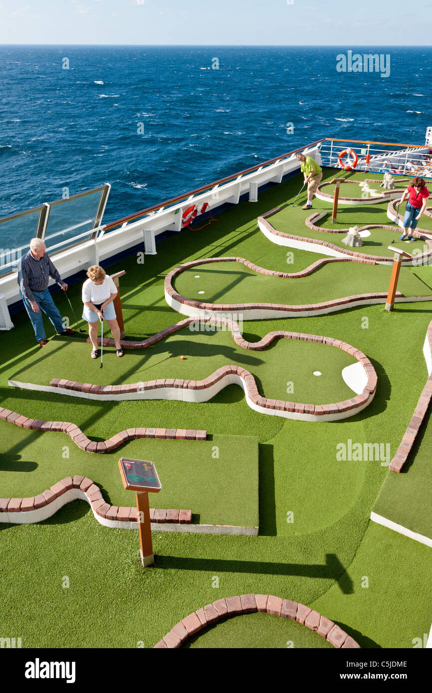 Cruise passengers playing miniature golf on the deck of Carnival's Triumph cruise ship in the Gulf of Mexico Stock Photo