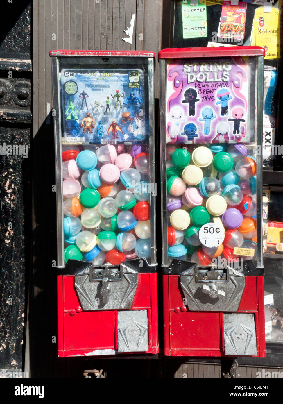 brightly painted nostalgic gumball gum ball machines machine dispensing favors mounted on Ninth Avenue storefront New York City Stock Photo
