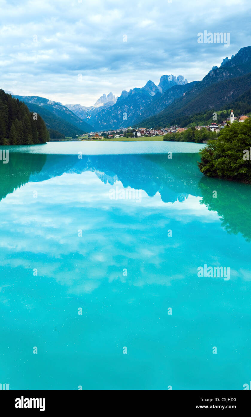 Tranquil summer Italian dolomites mountain lake and village view (Auronzo di Cadore) Stock Photo
