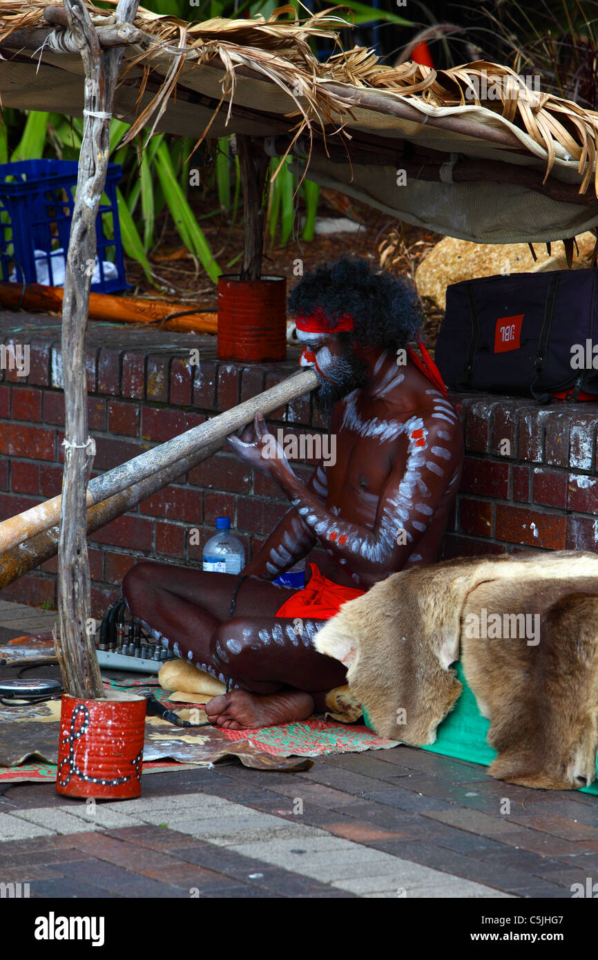 Aboriginal man play didgeridoo with painted body in Circular Quay Sydney Harbour Australia Stock Photo