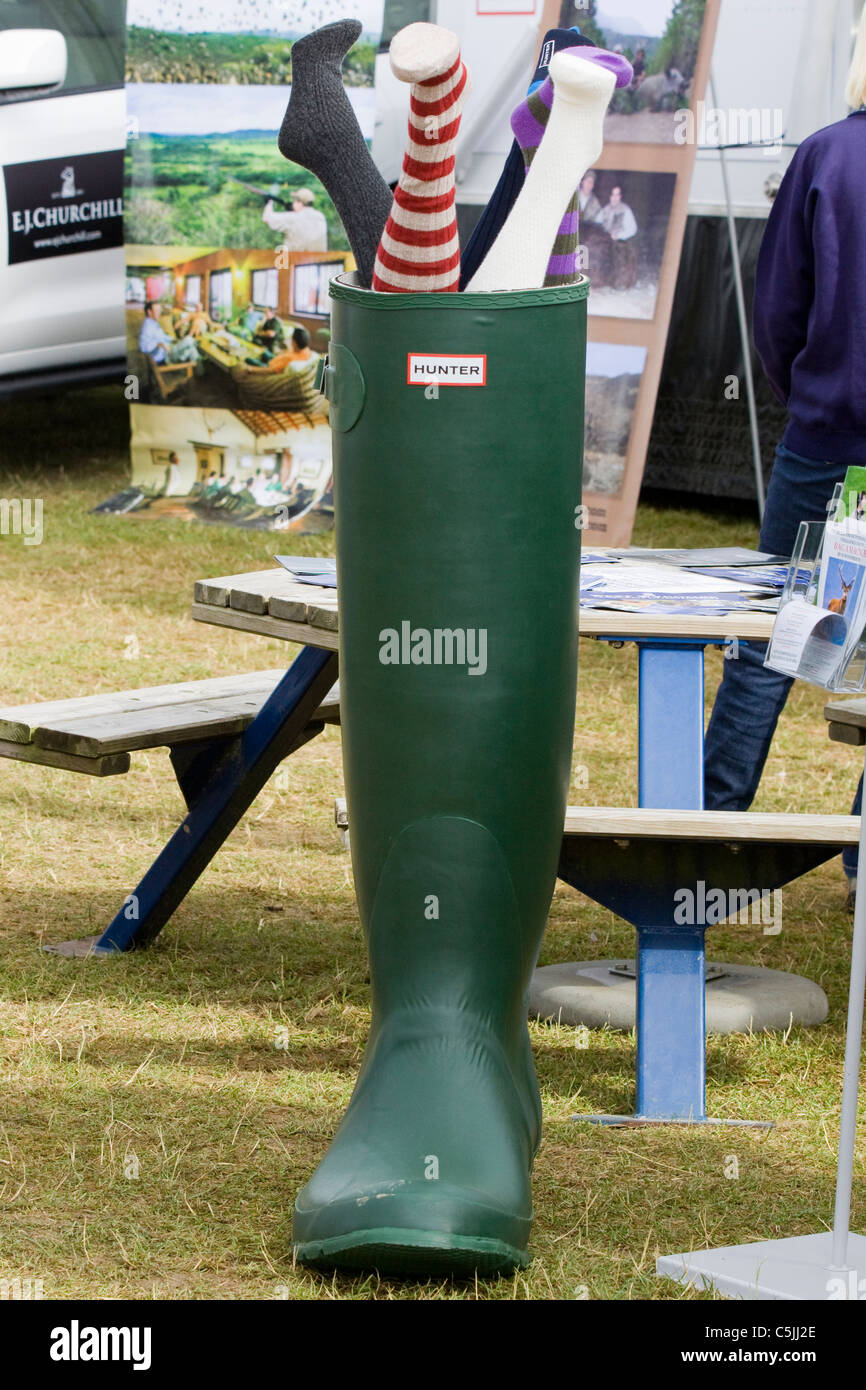 A Giant Wellington Boot with Legs sticking out the top Stock Photo