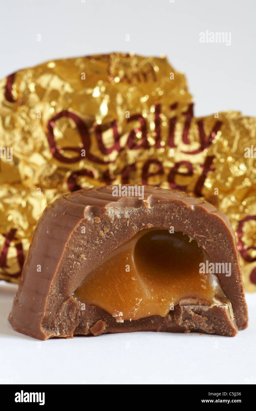 Quality Street soft caramel chocolate bitten into to show contents on white background Stock Photo