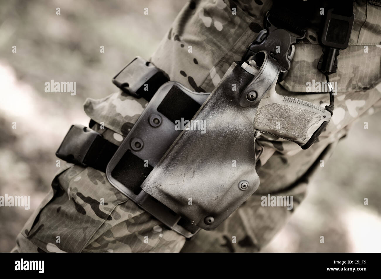 gun in holster on commando soldier's leg Stock Photo