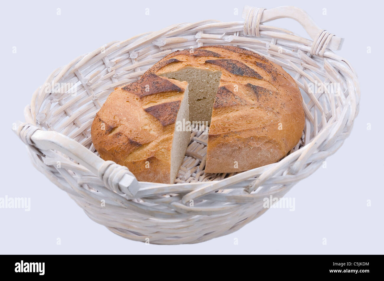 Cut round loaf of bread in wicker basket Stock Photo