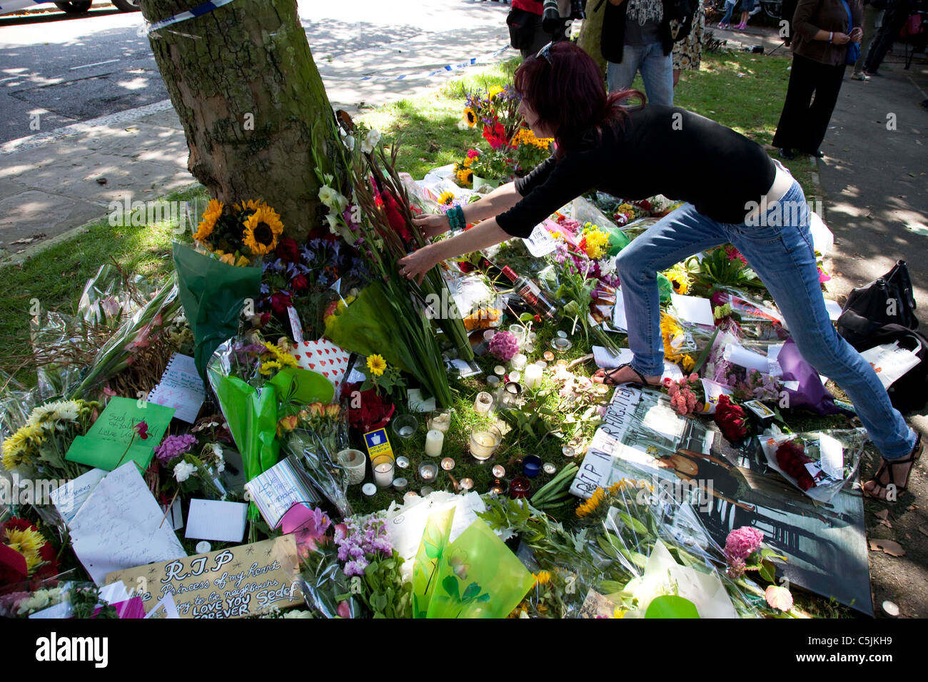 Fans bring flowers and messages to a memorial to dead singer Amy Winehouse, London. Stock Photo