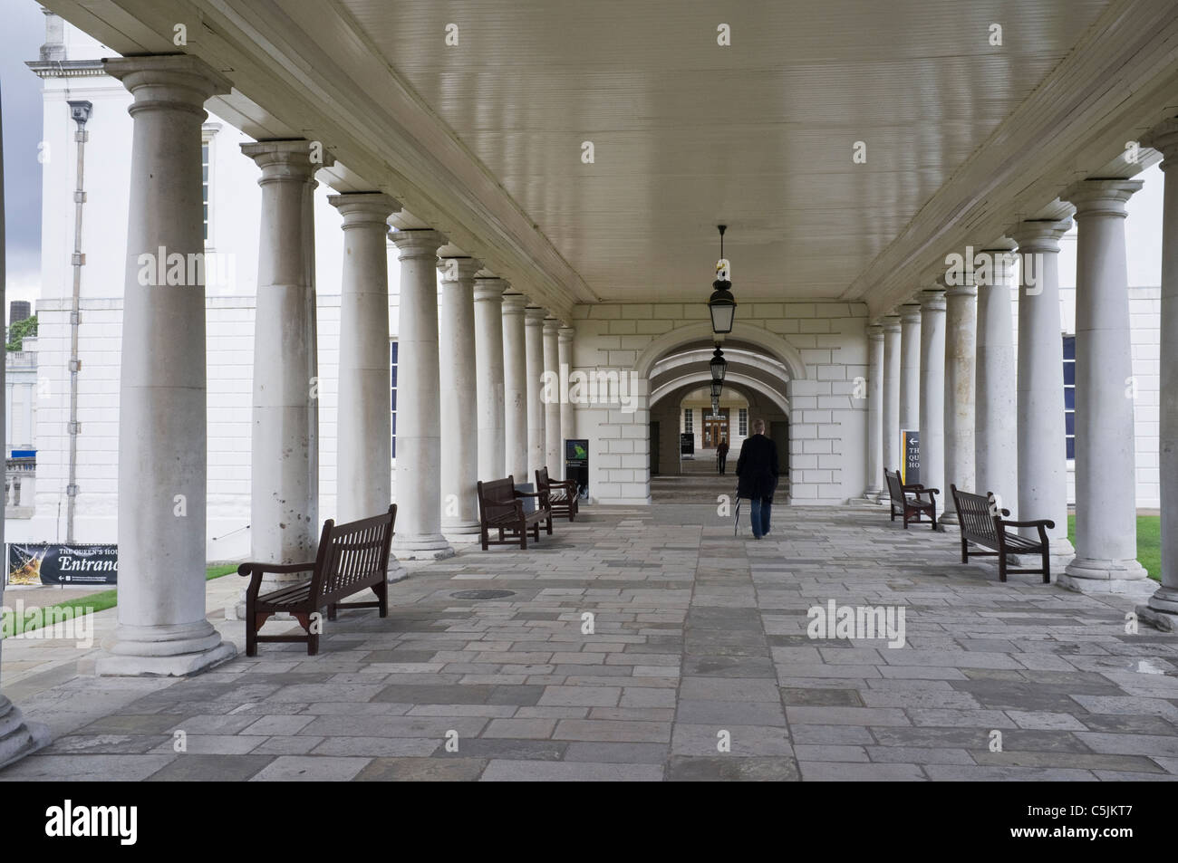 Greenwich, London, England, UK, Britain. Man walking through the National Maritime Museum colonnade to The Queen's House Stock Photo