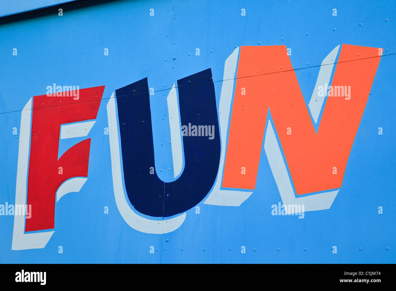 UK, Britain, Europe. The word Fun painted in bright colours on a blue door Stock Photo