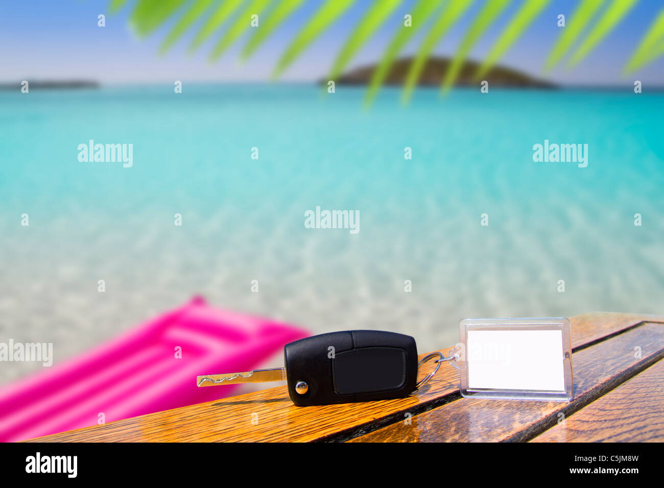 Car rental keys on wood table with blank paper in vacation tropical beach Stock Photo