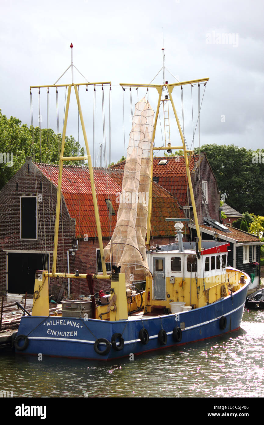 a yellow and blue fishing boat in the harbor of Enkhuizen Stock Photo