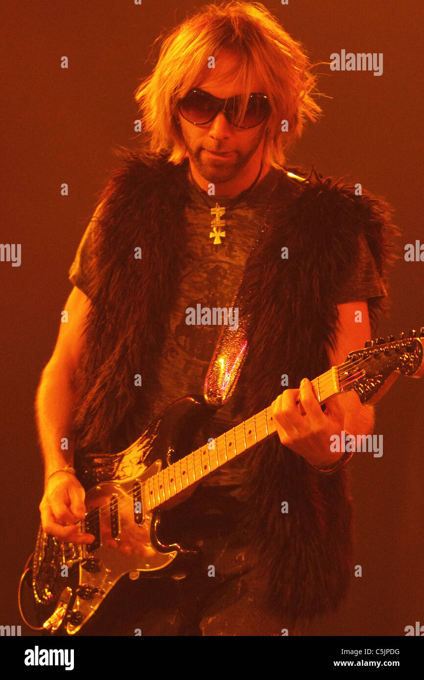 The lead guitar player of a rock and roll band performs on stage with