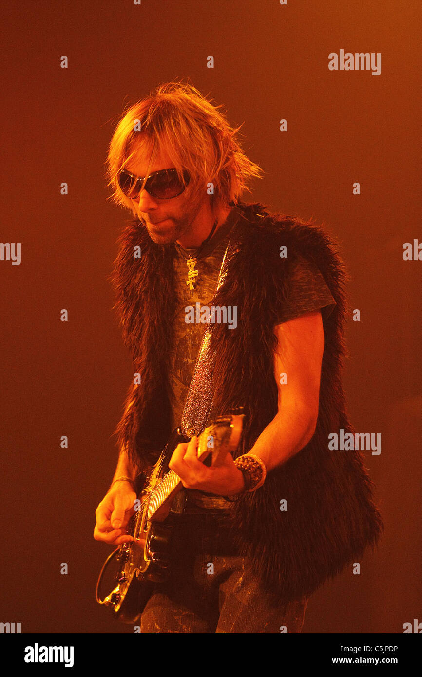 The lead guitar player of a rock and roll band performs on stage with