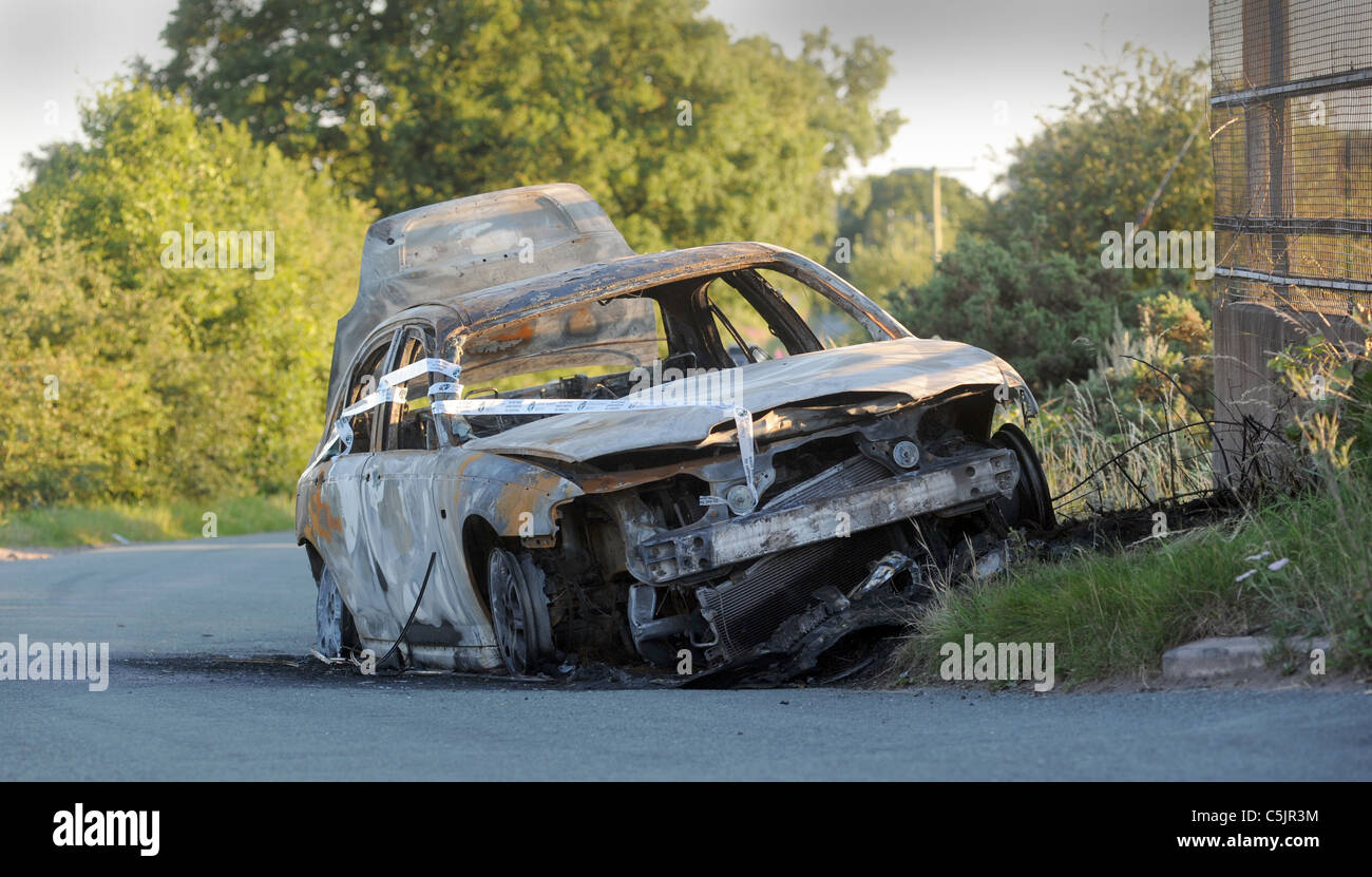BURNED OUT STOLEN ABANDONED CAR DUMPED IN COUNTRY LANE,UK Stock Photo