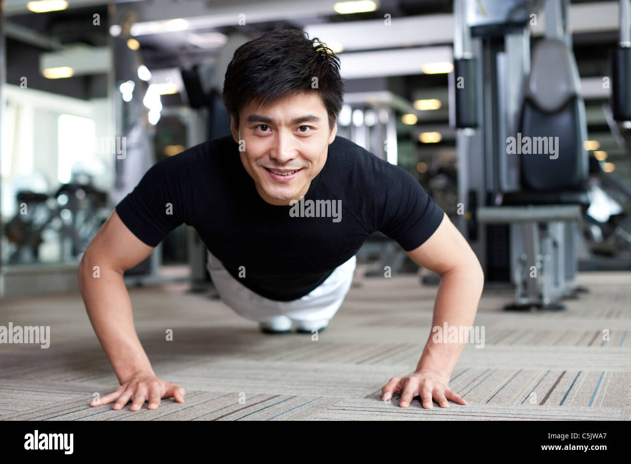 Young Man Doing Push-ups at Gym Stock Photo - Alamy