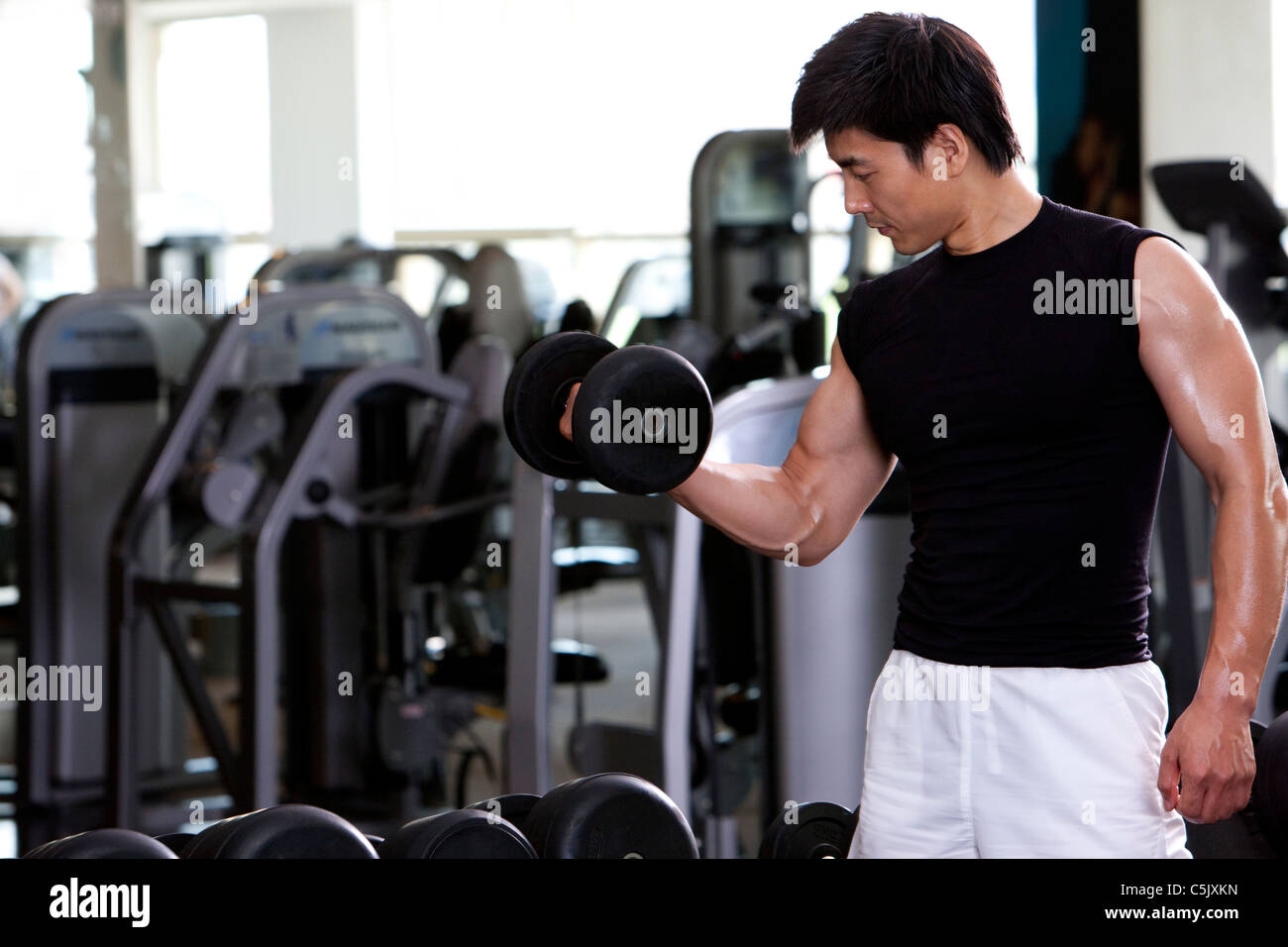 Mid-Adult Man Lifting Weights Stock Photo