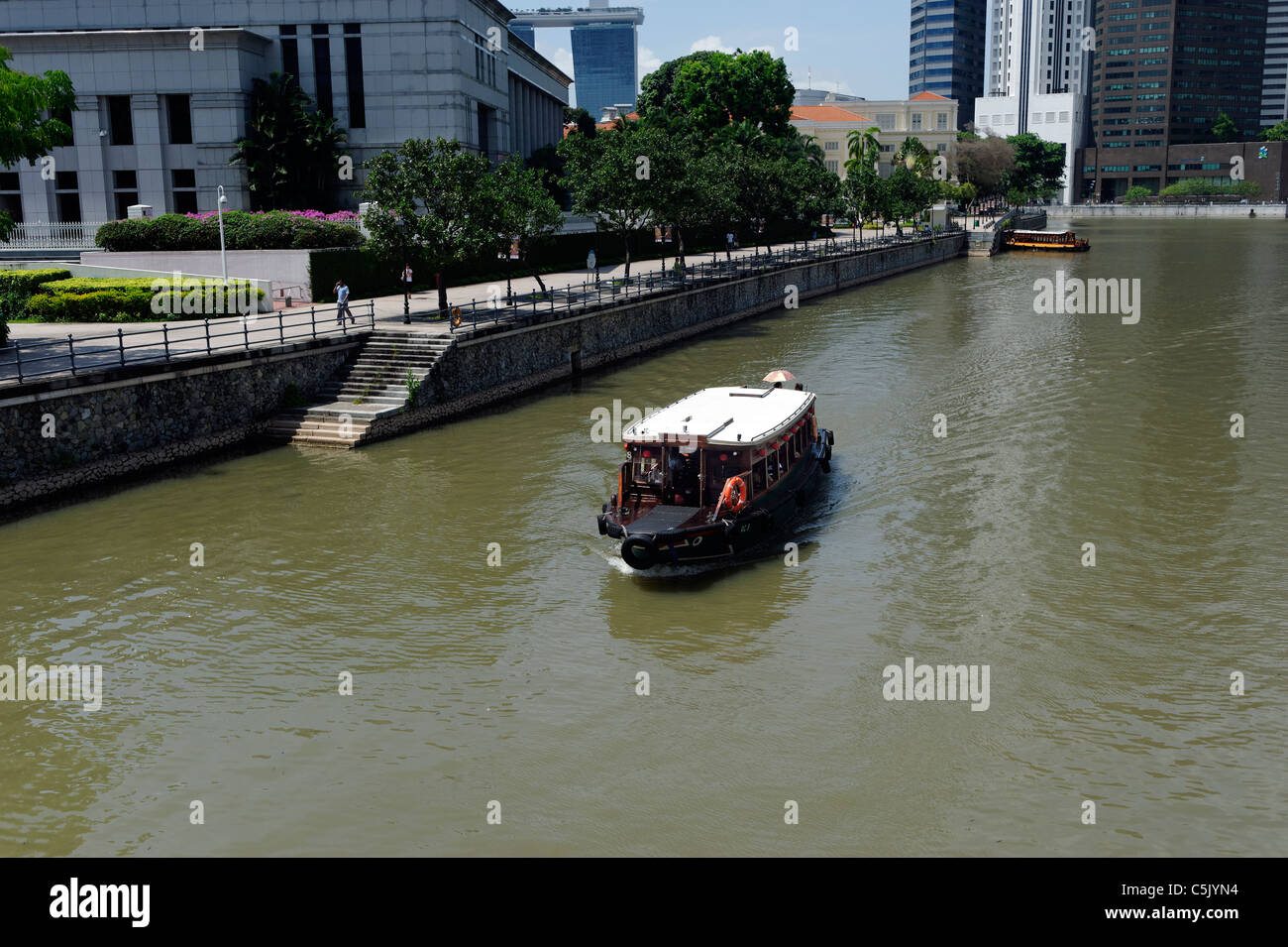 Tour boat on the Singapore River by Raffles Landing. Stock Photo