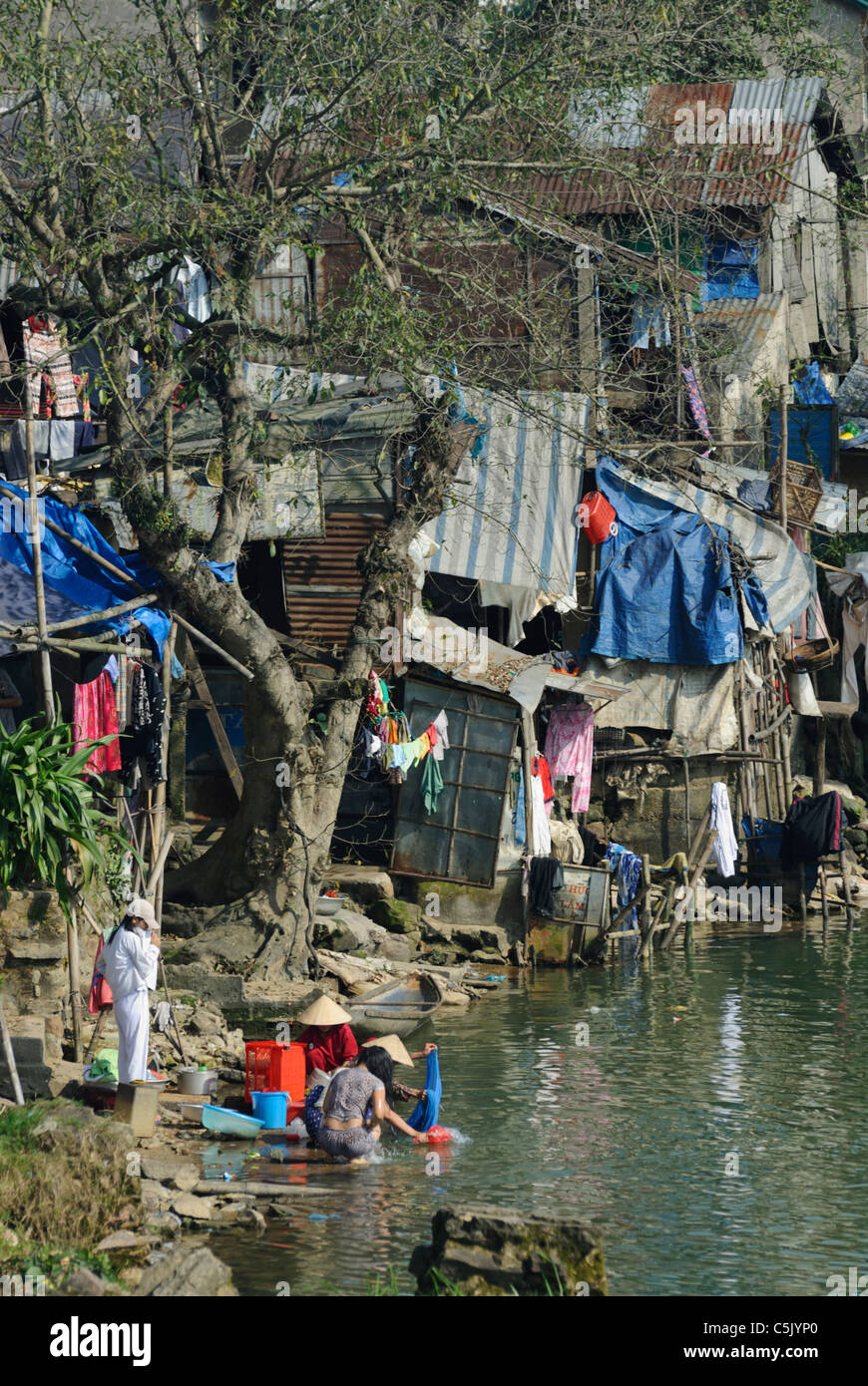 Asia, Vietnam, Hue. Poor peoples housing at the banks of the Huong or Perfume River Stock Photo