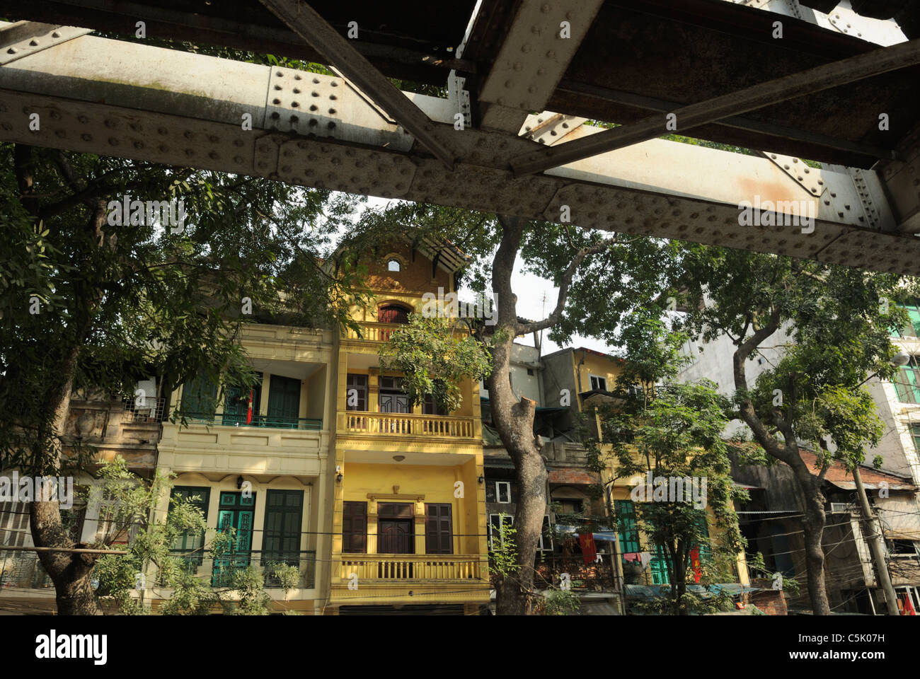 Asia, Vietnam, Hanoi. Hanoi old quarter. French colonial style housing next to the railway bridge. Stock Photo