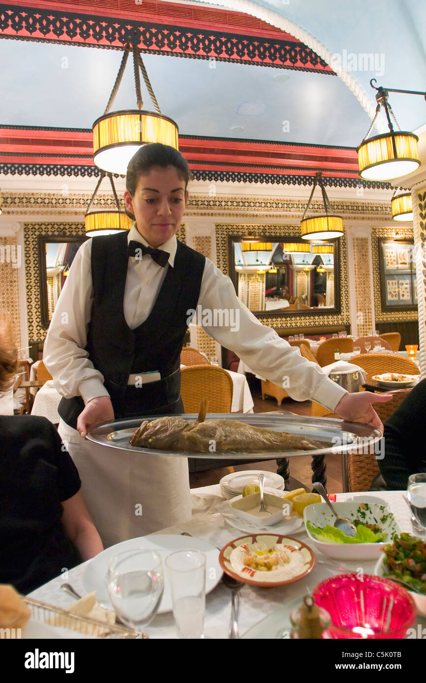 Waitress serving fish in restaurant, Beirut, Lebanon Stock Photo