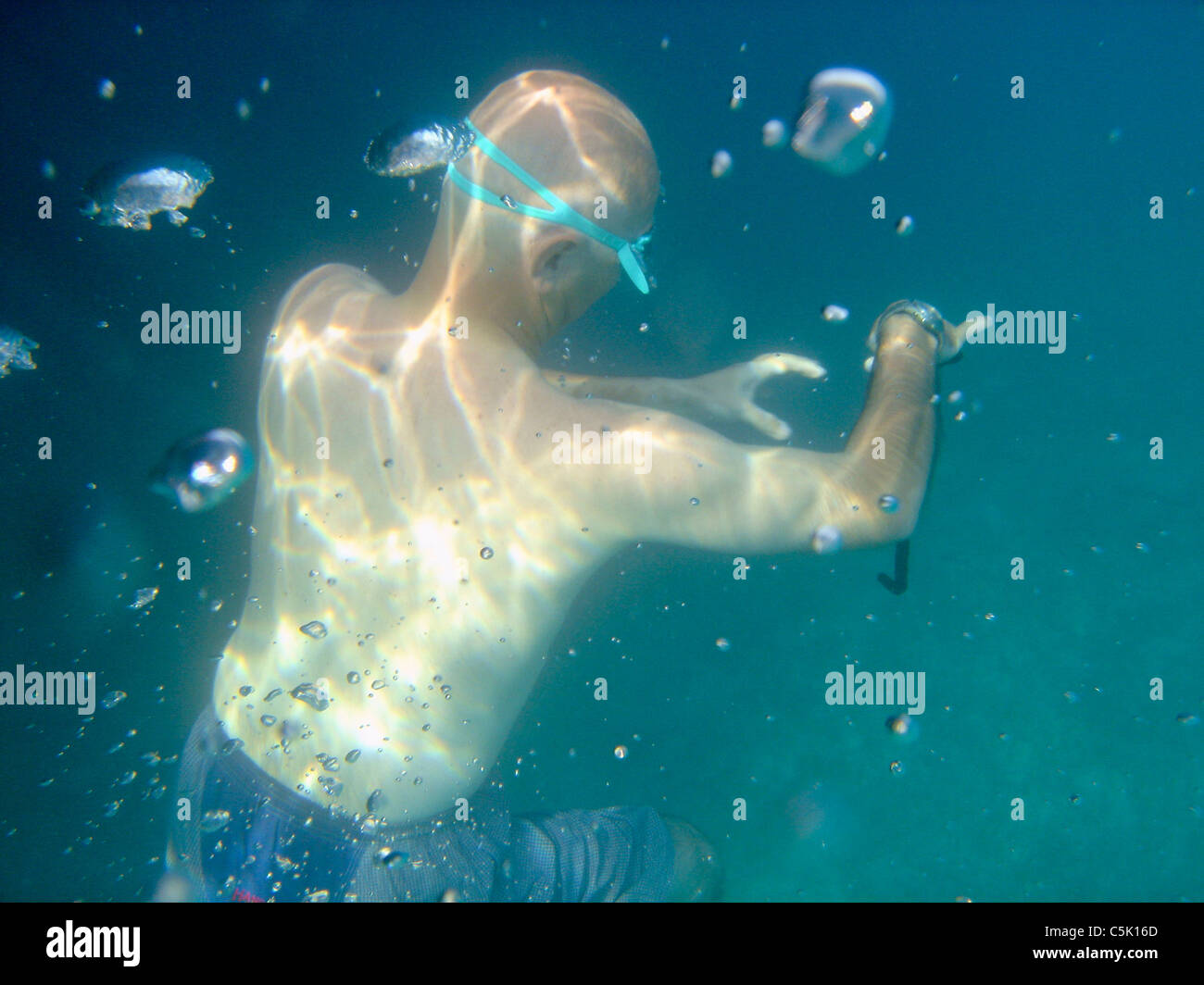 Bald man wearing swim goggles underwater, Bodrum, Gokova, Turkey Stock Photo