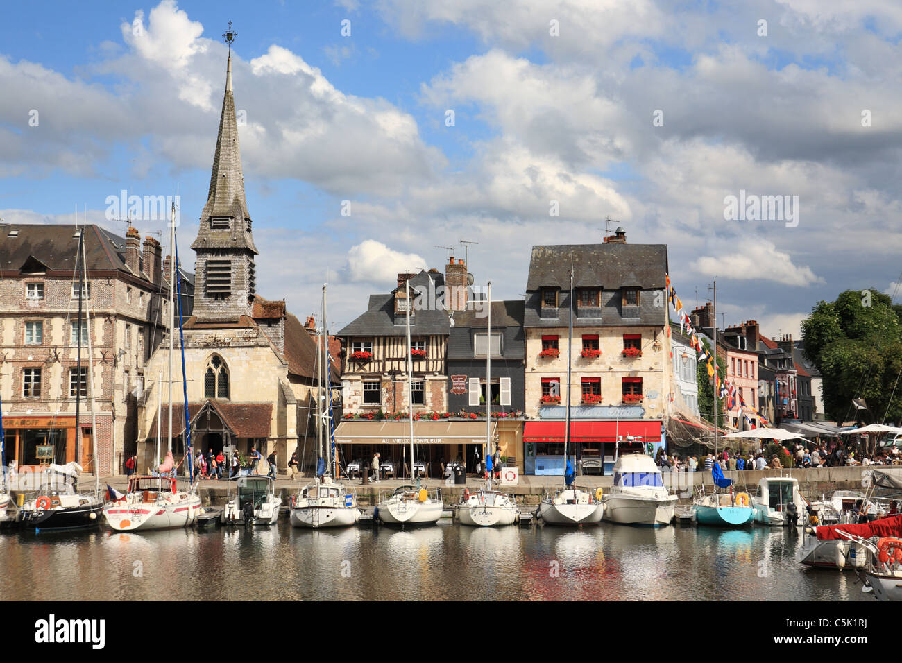 Church and historic buildings along the Quai St Etienne with yachts moored in the foreground, Honfleur, Normandy, France Stock Photo