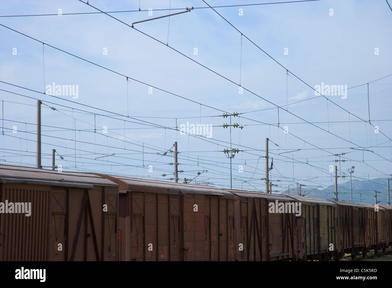 Freight train and power lines as seen from inside the railroad station, Fevzipasa, near Gaziantep / Antep, Turkey Stock Photo