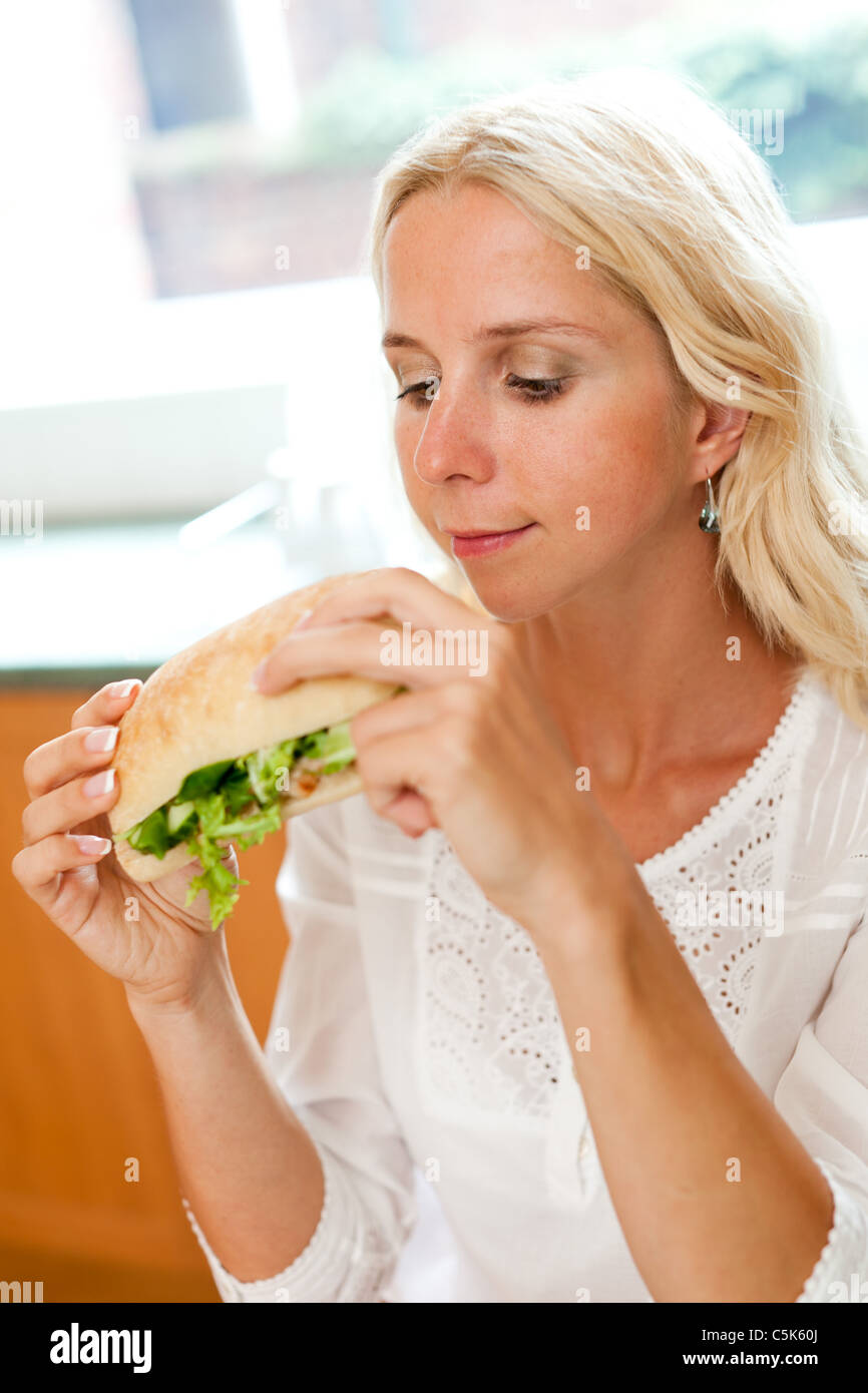 Blonde girl eating healthy sandwich Stock Photo