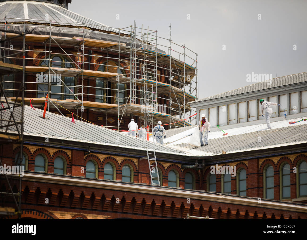 Building restorers working roof of historic Smithsonian's Arts and Industries Museum Stock Photo
