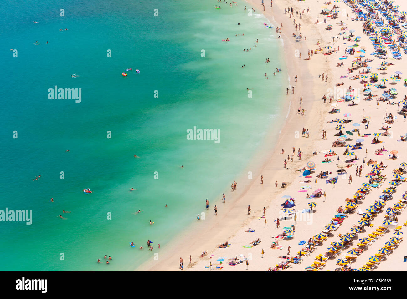 People sunbathing, swimming and relaxing at Playa Amadores beach, Gran Canaria, aerial view Stock Photo