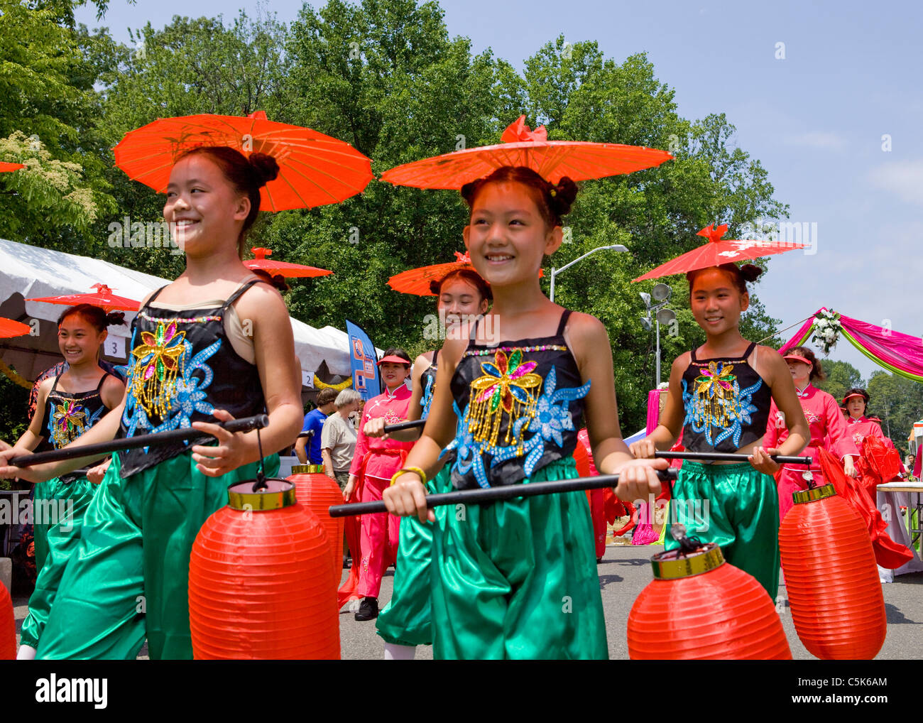 Young Chinese girls carrying paper lanterns and wearing paper parasols in a parade Stock Photo