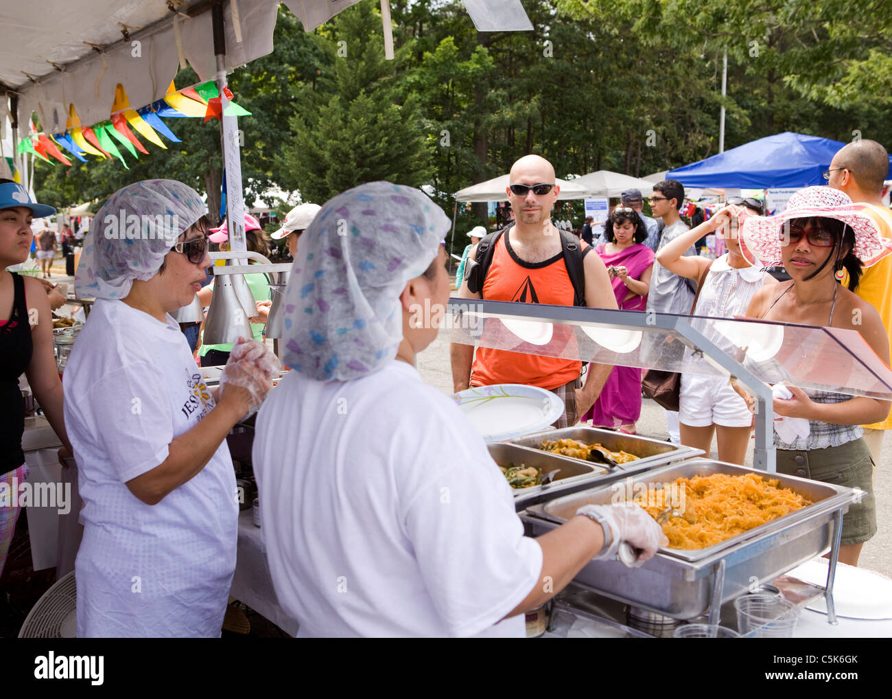 Food caterers serving patrons at an outdoor festival Stock Photo