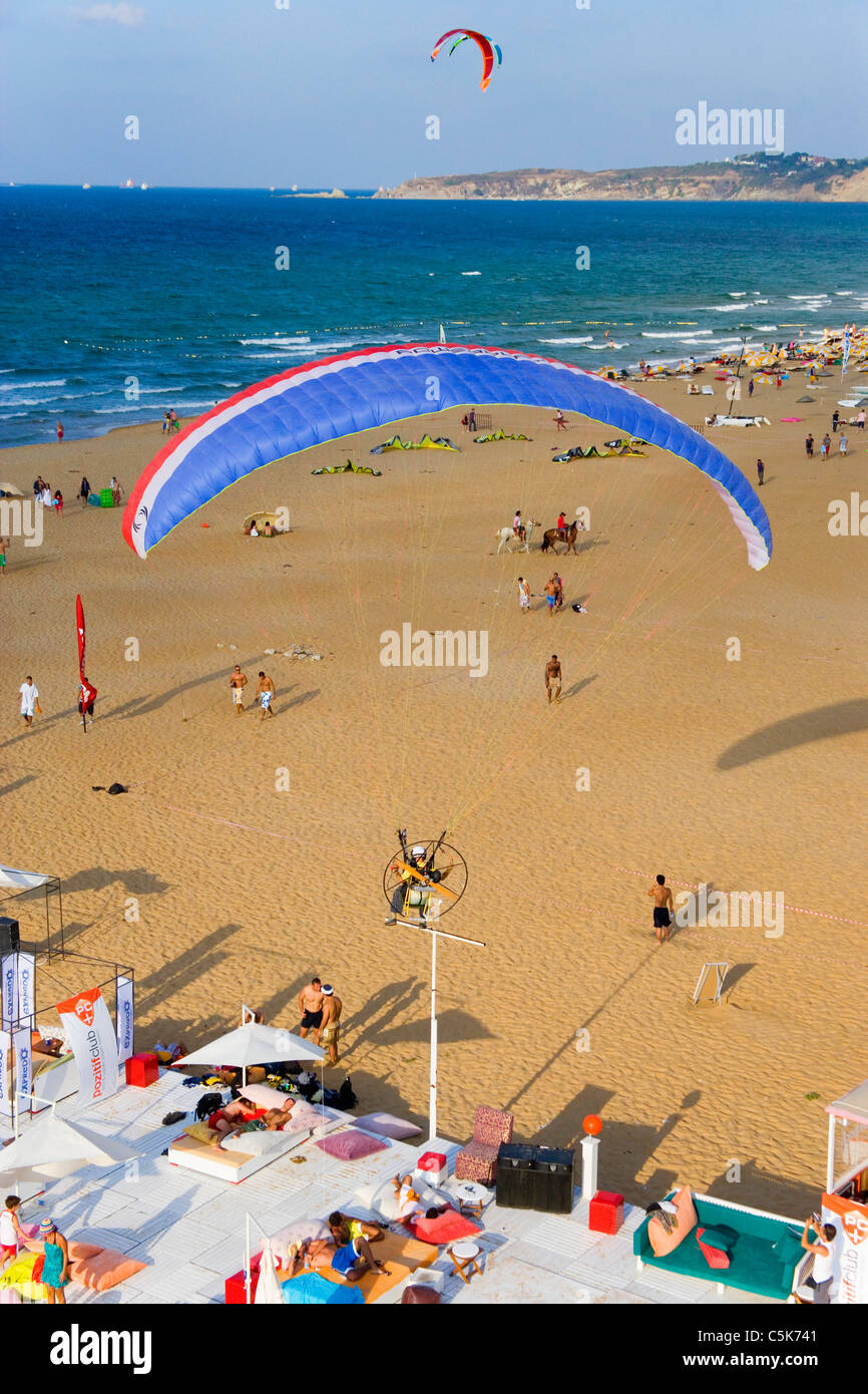 Powered paraglider flying over people enjoying the sun, aerial, Burc Beach, Gumusdere, Black Sea coast of Istanbul, Turkey Stock Photo