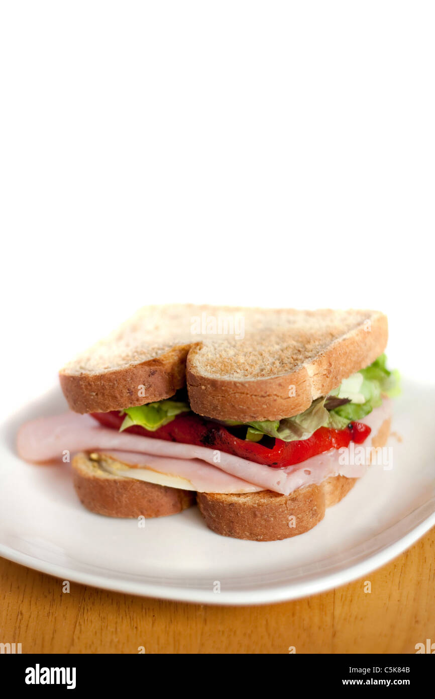 A ham and cheese sandwich on a plate isolated over white. Shallow depth of field. Stock Photo