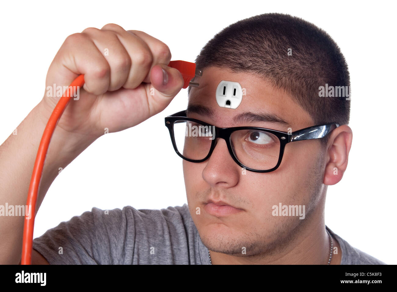 Conceptual image of a young man holding an electrical chord unplugged from the outlet on his forehead. Stock Photo