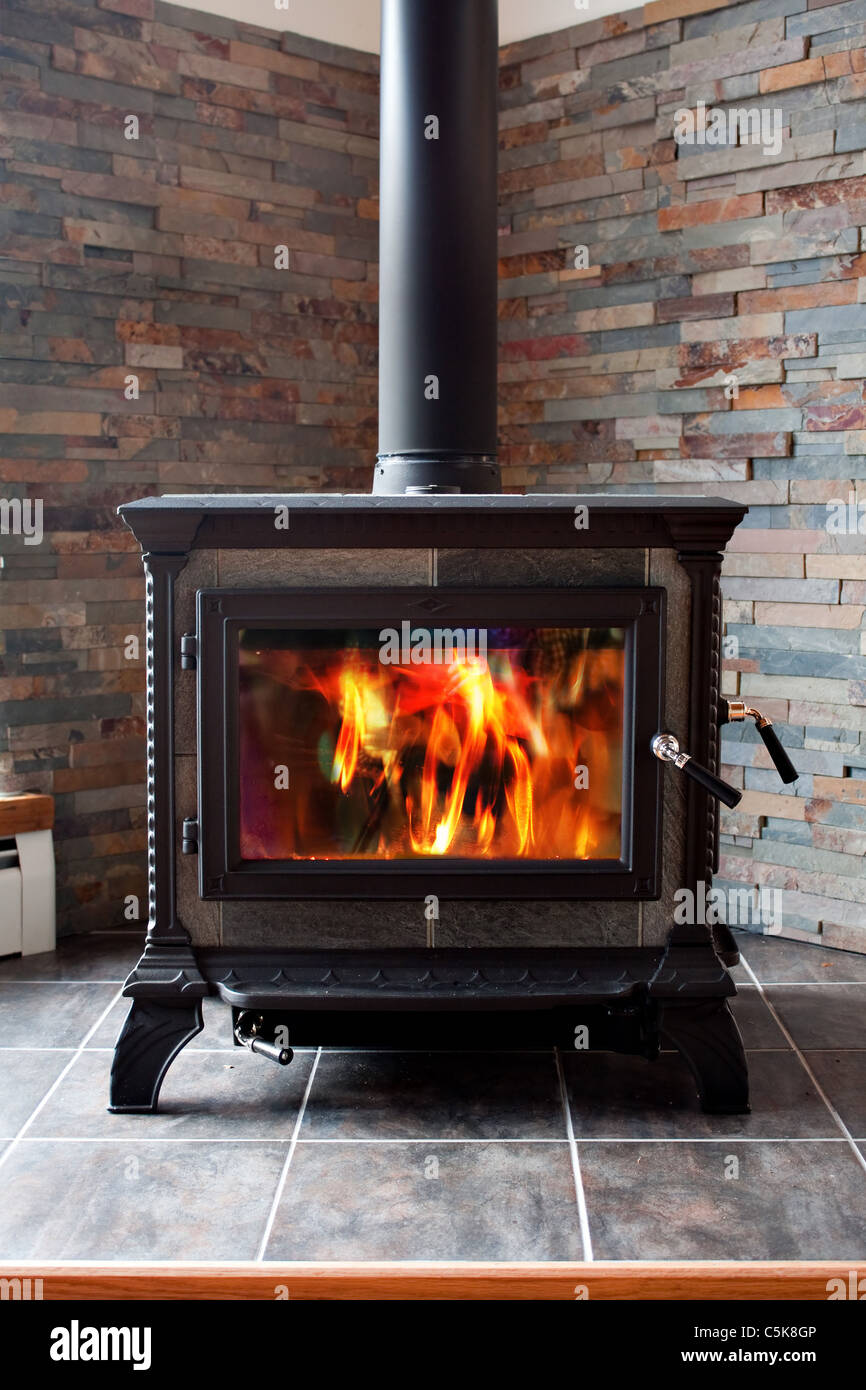 A New Cast Iron Wood Stove Burning Hot With Slate Tile Stock Photo