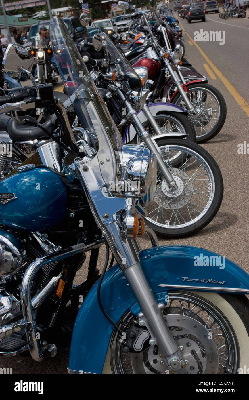 Vertical close-up of many motorcycle front wheels on street Stock Photo