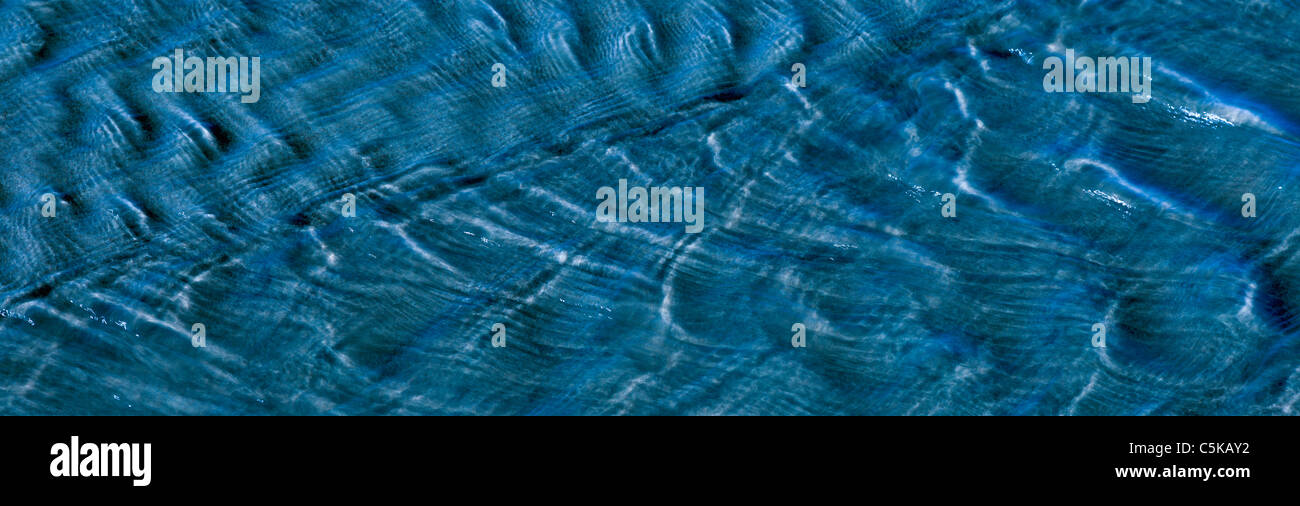 A shallow stream flowing over sand. Stock Photo