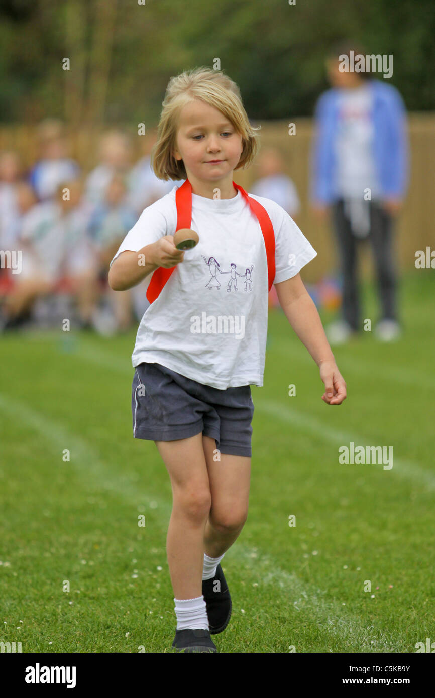 Young girl competing in egg and spoon race on sportsday Stock Photo