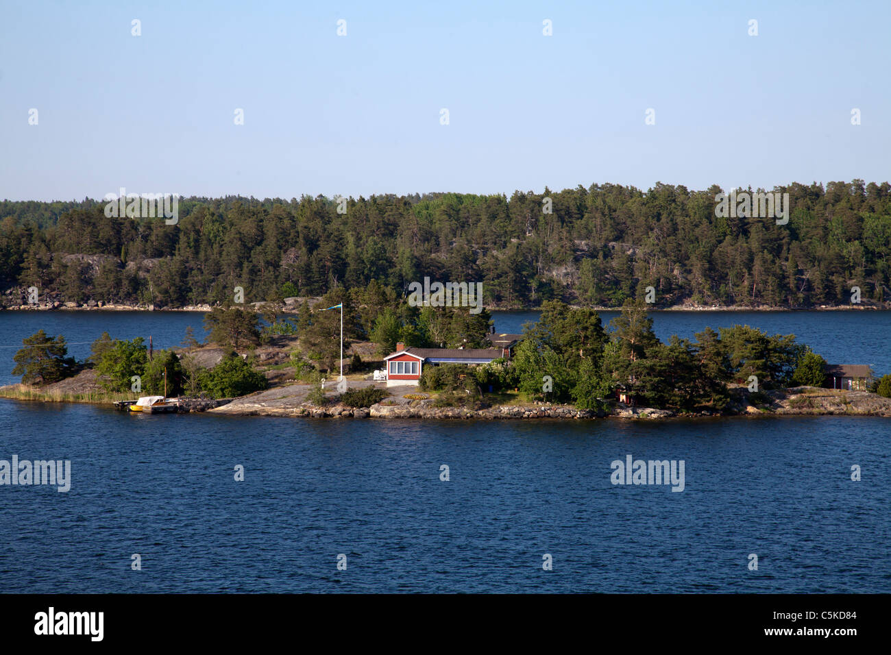 Swedish idyllic summer landscape with island in Stockholm archipleago and swedish national flag Stock Photo