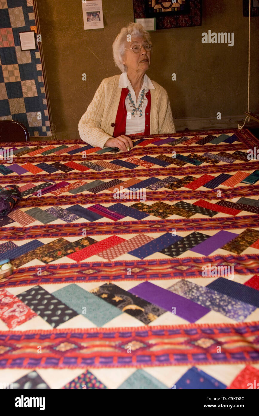 Senior artist makes quilt. Stock Photo