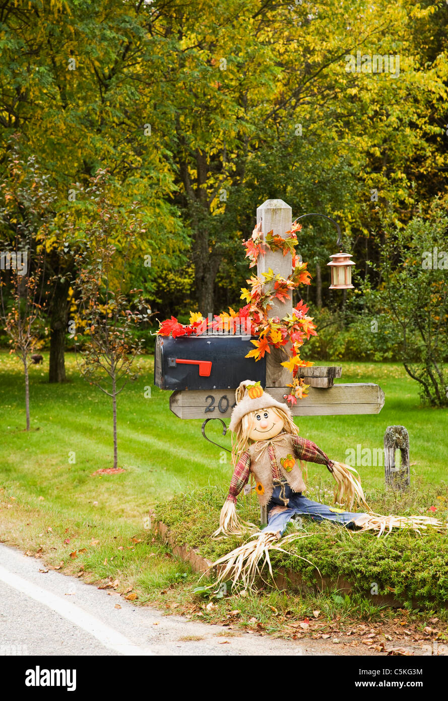 Fall Season Decoration Of Scarecrow And Red Leaves On Mailbox