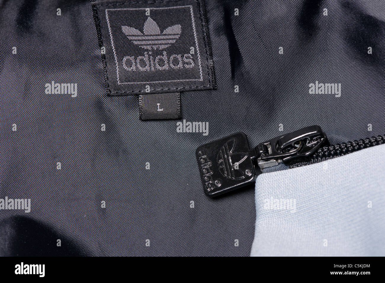 Adidas sportswear men's windbreaker jacket full zip hooded in nylon. With trefoil logo. Label detail Stock Photo