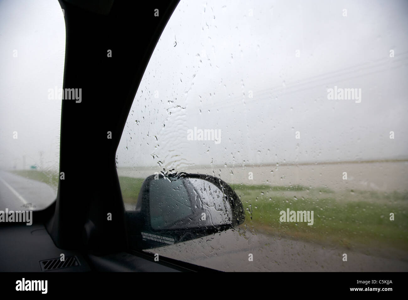 looking out of car driving through heavy rainstorm and flooding in southern saskatchewan canada Stock Photo