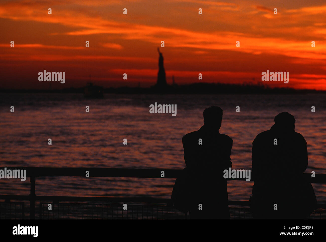 Two in silhouette, Statue of liberty, Battery Park, NYC Stock Photo