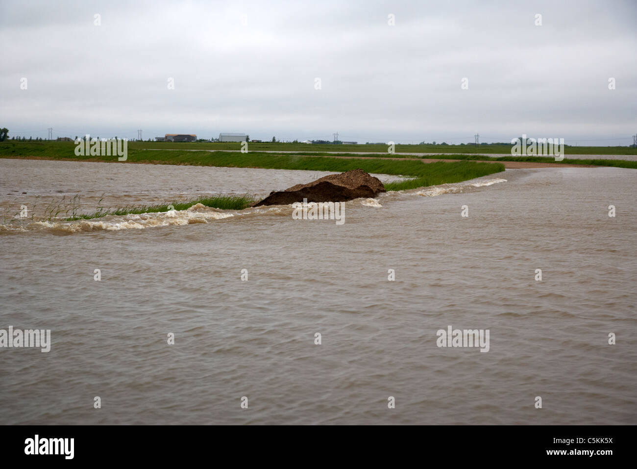 heavy rainstorm bursting flood defences and flooding fields in southern saskatchewan canada Stock Photo