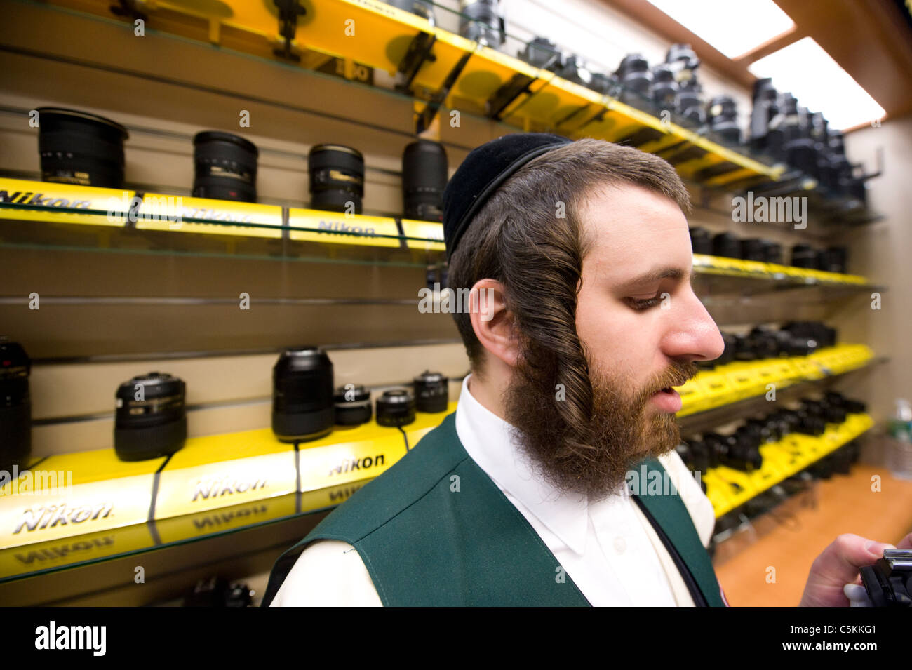 Jewish man in front of a Nikon lens display in a camera store, New York City. © Craig M. Eisenberg Stock Photo